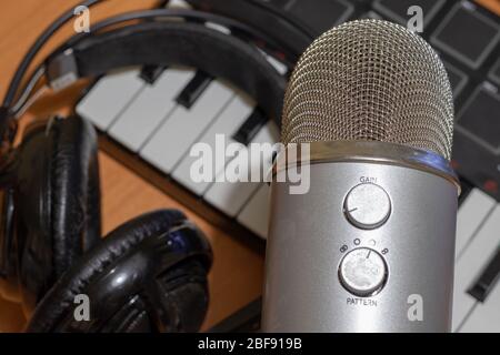 Home musical studio with audio equipment: microphone, headphones and piano keyboard. Electronic music production Stock Photo