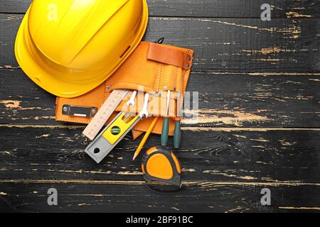 Builder's tools and hardhat on wooden background Stock Photo