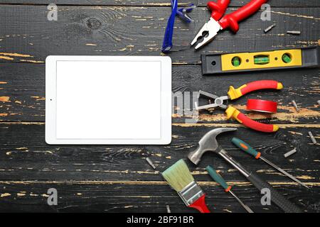 Builder's tools with tablet computer on wooden background Stock Photo