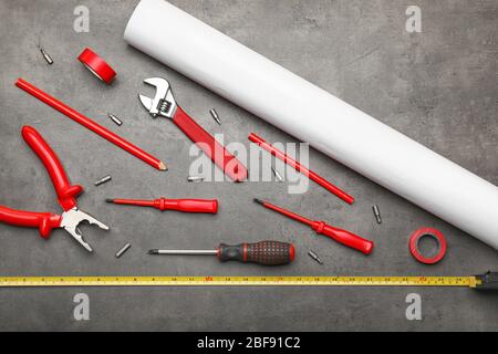 Builder's tools and blueprint on dark background Stock Photo