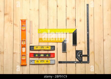 Builder's rulers on wooden background Stock Photo