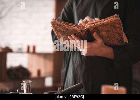 Male alchemist with spell book in laboratory, closeup Stock Photo