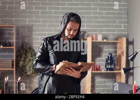 Male alchemist with spell book in laboratory Stock Photo