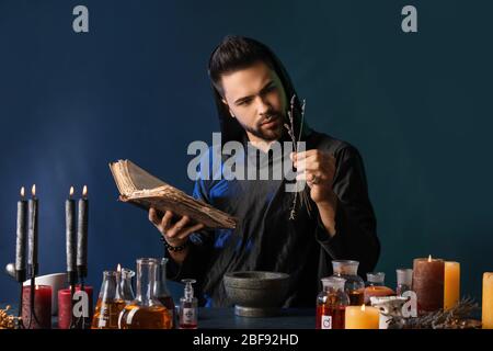 Male alchemist making potion on dark background Stock Photo