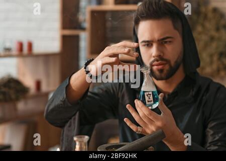 Male alchemist making elixir in laboratory Stock Photo