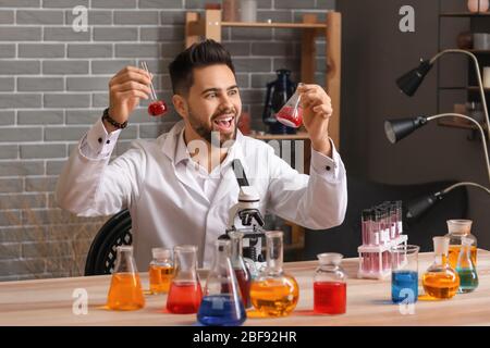 Crazy male alchemist working in laboratory Stock Photo