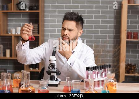 Male alchemist working in laboratory Stock Photo
