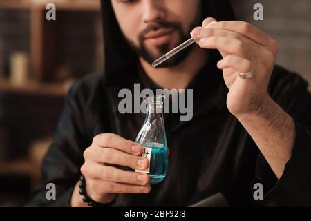 Male alchemist making elixir in laboratory Stock Photo