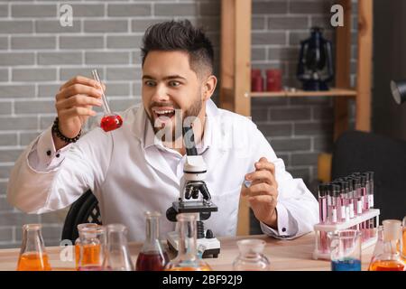 Crazy male alchemist working in laboratory Stock Photo