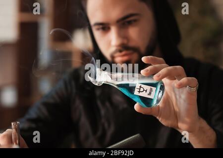 Male alchemist making elixir in laboratory Stock Photo