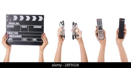 Many hands with movie clapper with eyeglasses and remote controls on white background Stock Photo