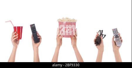 Many hands with popcorn, drink, remote controls and eyeglasses on white background Stock Photo