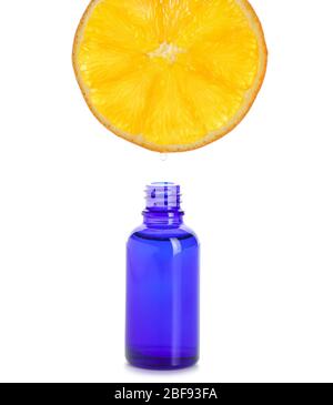 Essential oil dripping from orange slice into bottle on white background Stock Photo