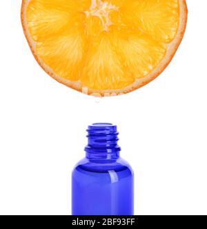 Essential oil dripping from orange slice into bottle on white background Stock Photo