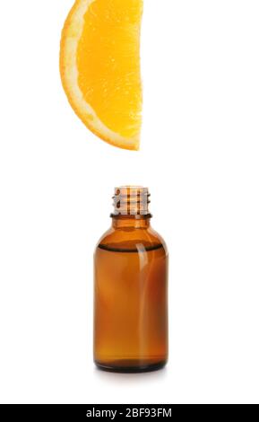 Essential oil dripping from orange slice into bottle on white background Stock Photo