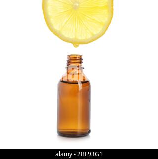 Essential oil dripping from lemon slice into bottle on white background Stock Photo