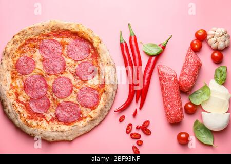 Tasty pizza with ingredients on color background Stock Photo