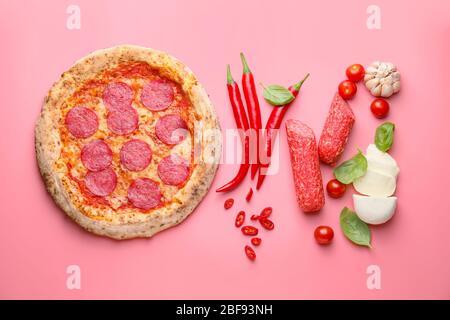 Tasty pizza with ingredients on color background Stock Photo