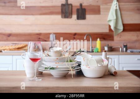 Many dirty dishes on kitchen table Stock Photo