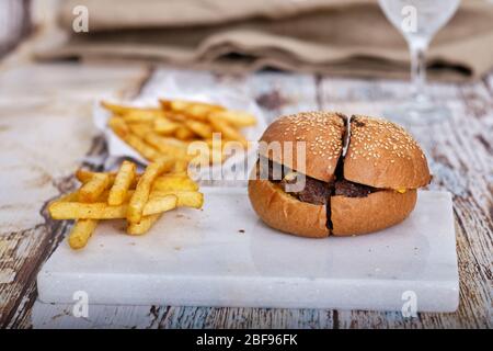 Fast Food, Hamburger. Special veal prepared hamburger, french fries and double cheddar cheese. Close-up fresh delicious tasty homemade burger. Stock Photo