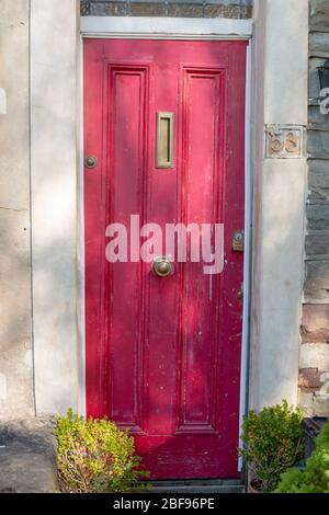 Bristol-April-2020-England-a close up view of a red front door that has the paint peeling Stock Photo