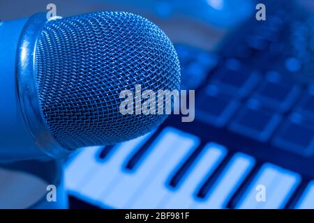 Close up shot microphone in producer musical studio with professional synthesizer Stock Photo
