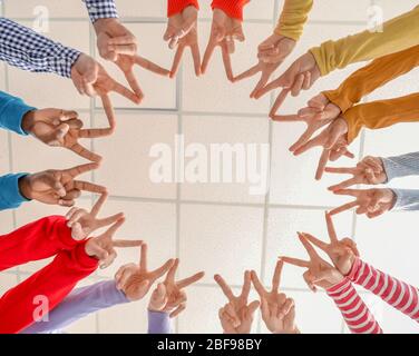 Group of people putting hands together indoors, bottom view. Unity concept Stock Photo