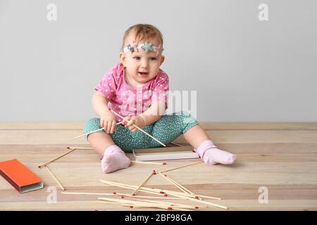 Girl playing with matches. Dangerous situation at home. A small