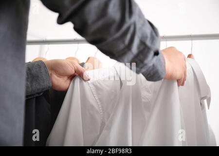 Young male stylist choosing clothes from rack, closeup Stock Photo