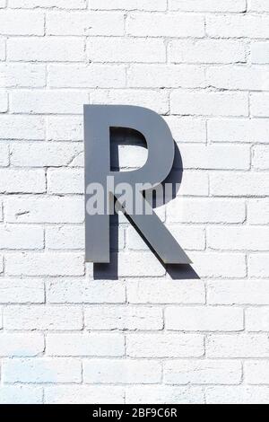 The letter R as a capital letter on a white brick wall Stock Photo