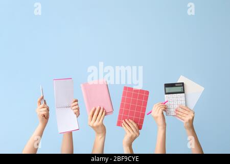 Many hands with school supplies on color background Stock Photo