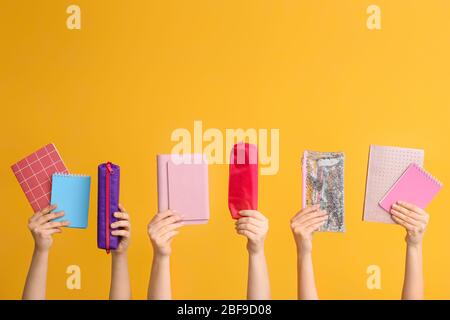 Many hands with school supplies on color background Stock Photo