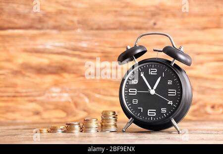 Alarm clock and money on table. Time management concept Stock Photo