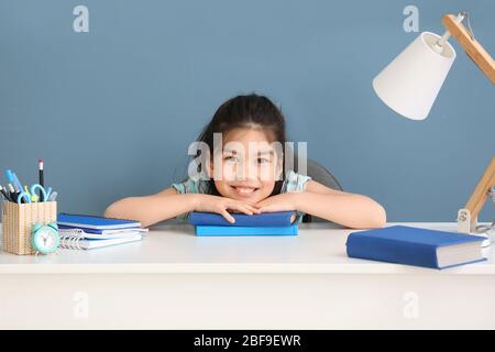 Little Asian girl doing homework at table Stock Photo
