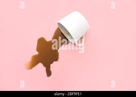 Overturned cup of coffee on color background Stock Photo
