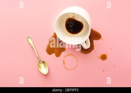 Overturned cup of coffee on color background Stock Photo