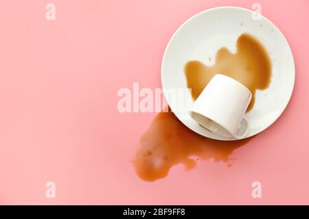 Overturned cup of coffee on color background Stock Photo