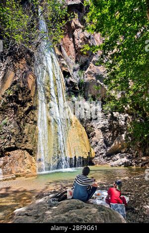 Family picnic by Mylonas waterfall, in Mylonas gorge, about 9 km east of Ierapetra town, Lasithi prefecture, Crete, Greece. Stock Photo