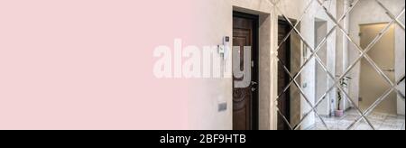 Bright entrance hall in a modern style with a large mirror on the wall. Comfortable living space in a city house. Stock Photo