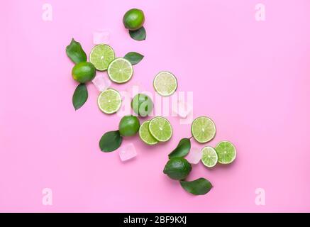 Fresh limes and ice cubes on color background Stock Photo
