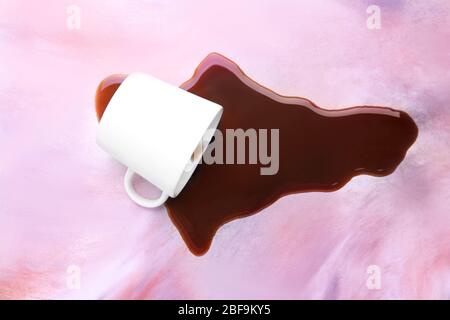 Overturned cup and spilled coffee on table Stock Photo
