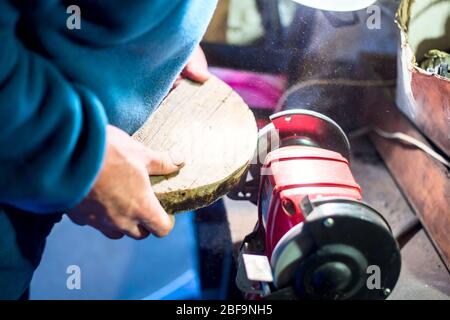 Young attractive white male, working on woodworking lathe machine in the carpenter workshop. Stock Photo