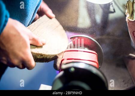 Young attractive white male, working on woodworking lathe machine in the carpenter workshop. Stock Photo