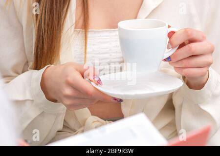 Woman holding cup of coffee during consultation with doctor while coffee break. Medical treatment. Stock Photo