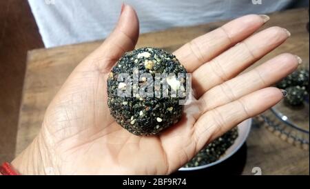 Black sesame seeds balls - sweet made with sesame and palm sugar. Tilgul Laddu or Til Gul balls for makar sankranti, Roasted thala balls. Stock Photo