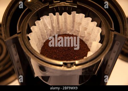 a paper filter is full of fresh coffee grinds ready for brewing Stock Photo