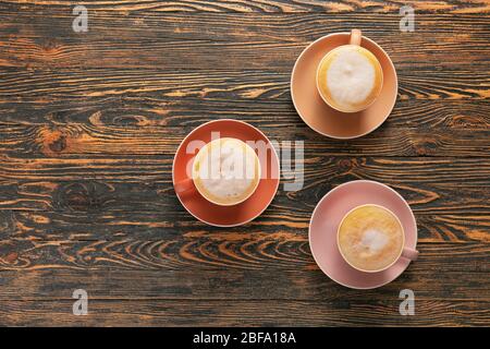 Cups of hot coffee on wooden table Stock Photo