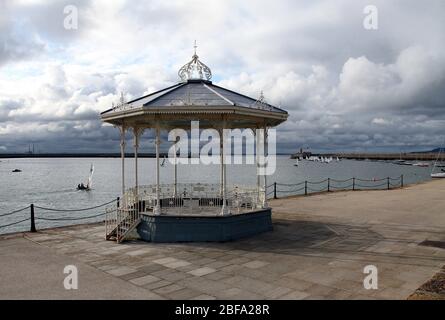 East Pier Victorian bandstand at Dun Leoghaire with Poolbeg Stacks in the distance Stock Photo
