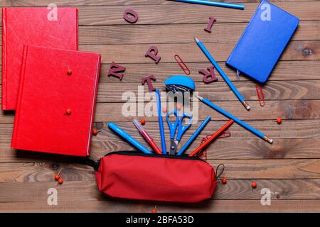 Pencil case and school stationery on wooden background Stock Photo