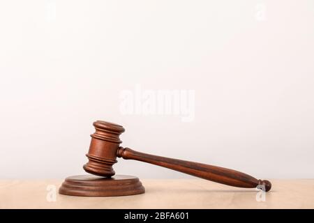 Judge's gavel on table against light background Stock Photo